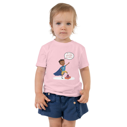 Pink toddler t-shirt with an image of the main character from Crystel Patterson's "Superheroes Here and There" wearing a cape (front) and the text "Superheroes Look Like Me" (back).